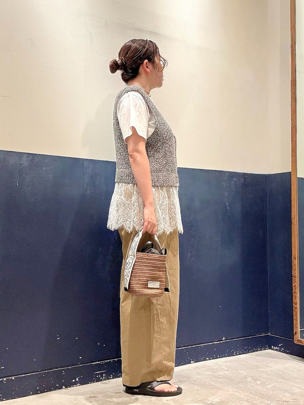 ブラウン系のトートバッグ、ベージュ系のデニムパンツ、ホワイト系のTシャツ/カットソーを着用したレディースの夏コーディネートの2枚目の写真
