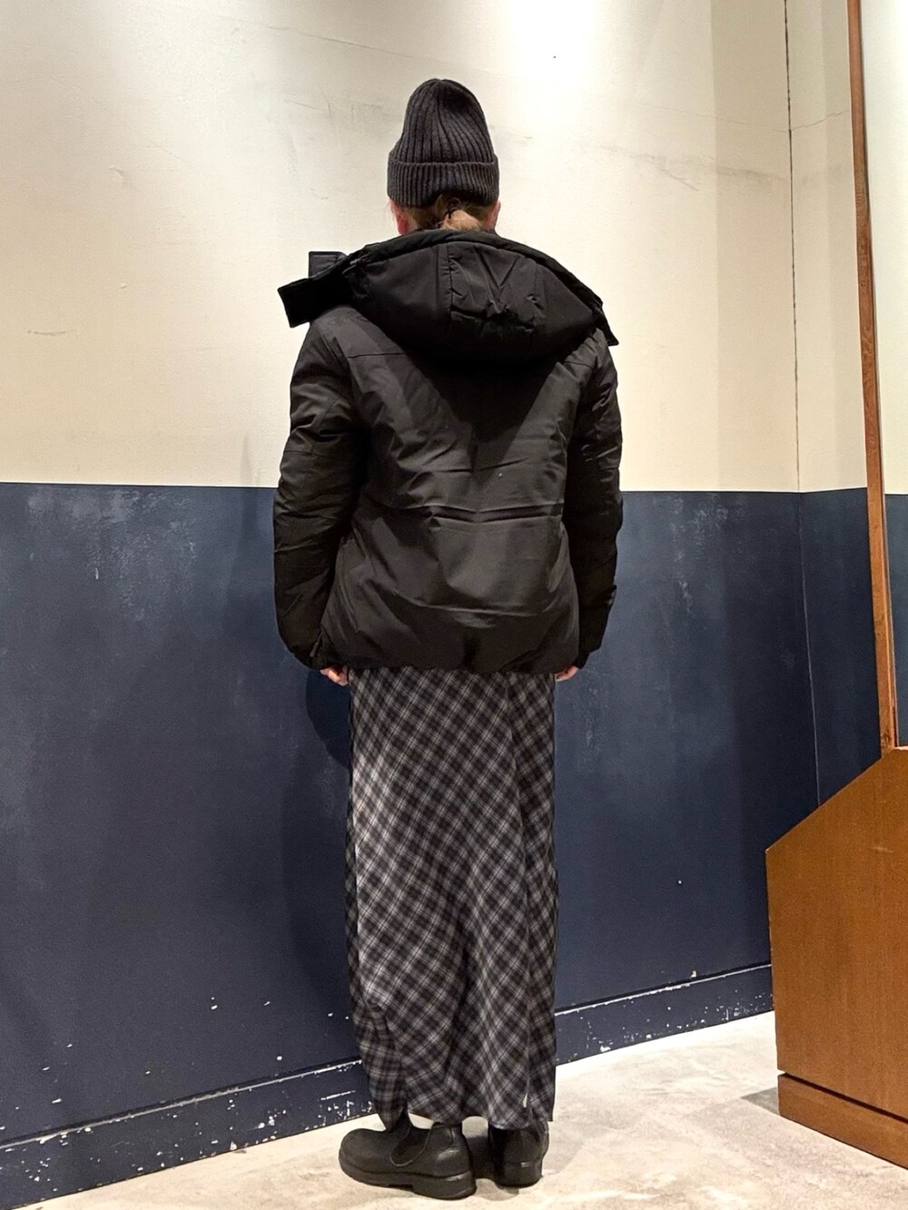 グレー系のスカート、グレー系のニット/セーター、ブラック系のダウンジャケット/コートを着用したレディースの冬コーディネートの3枚目の写真