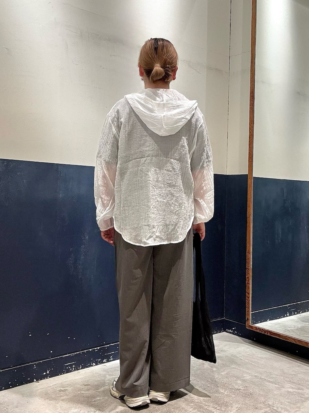 グレー系のデニムパンツ、ブラック系のTシャツ/カットソー、ブラック系のトートバッグを着用したレディースの春コーディネートの3枚目の写真