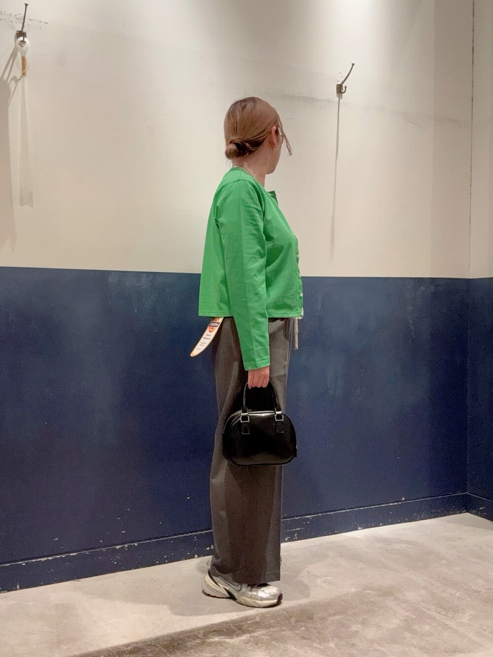 グリーン系のカーディガン/ボレロ、ホワイト系のTシャツ/カットソー、グレー系のパンツを着用したレディースの春コーディネートの2枚目の写真