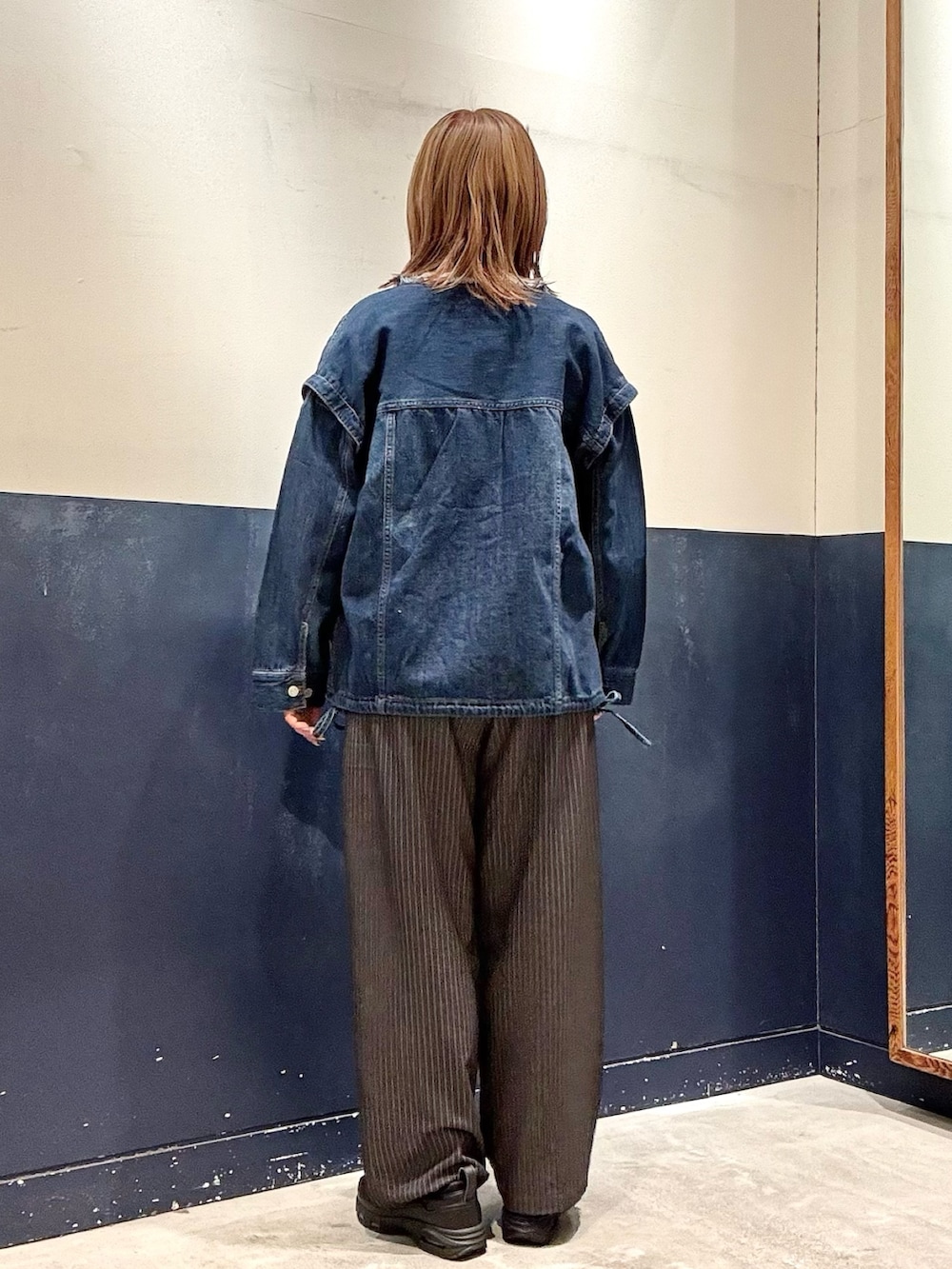 ブルー系のデニムジャケット、グレー系のスラックス、グレー系のスウェットを着用したレディースの冬コーディネートの3枚目の写真