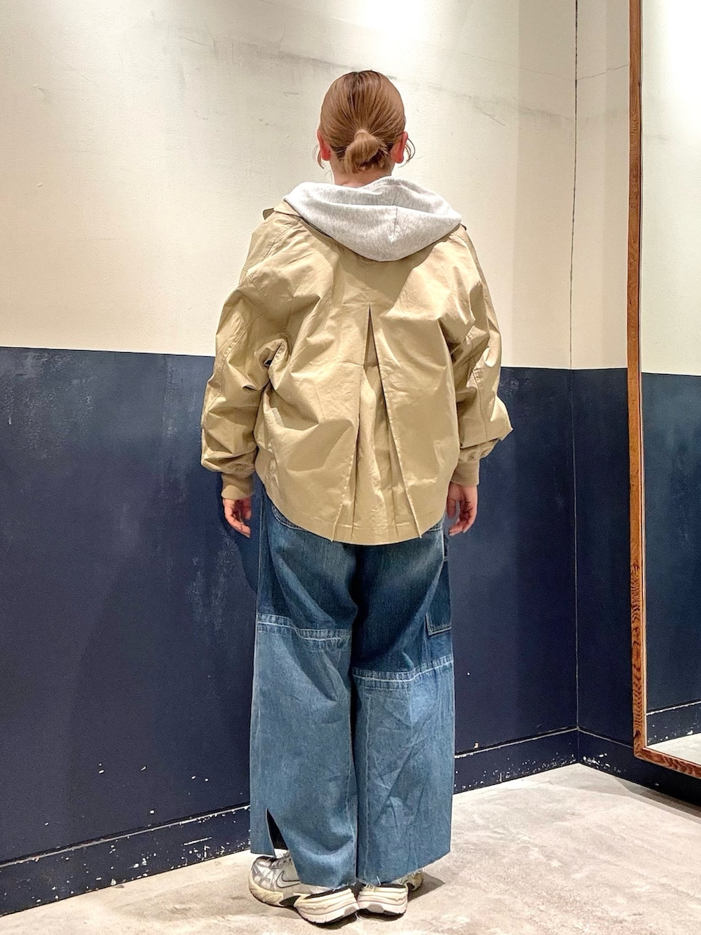 ブルー系のデニムパンツ、ベージュ系のトレンチコート、グレー系のTシャツ/カットソーを着用したレディースの春コーディネートの3枚目の写真