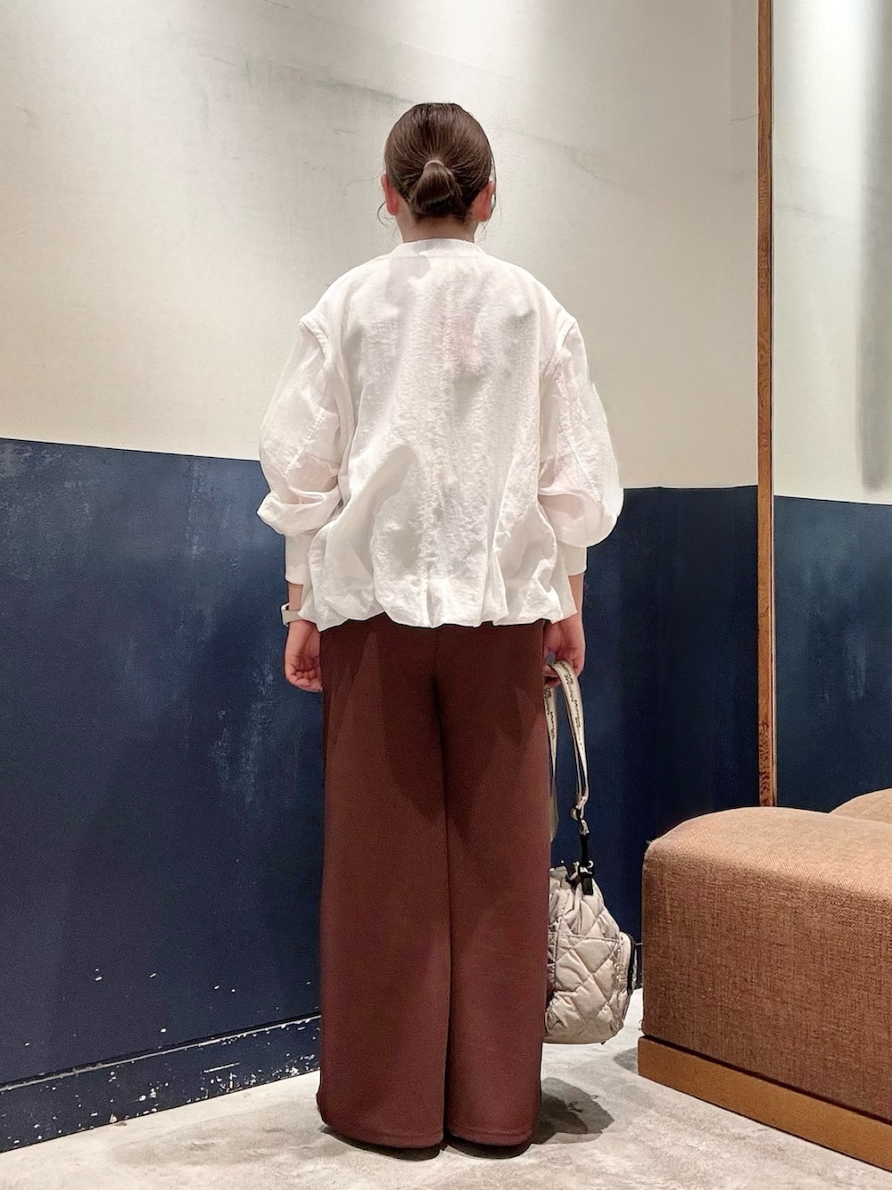 シルバー系のパンプス、ホワイト系のTシャツ/カットソー、ブラウン系のスラックスを着用したレディースの春コーディネートの3枚目の写真