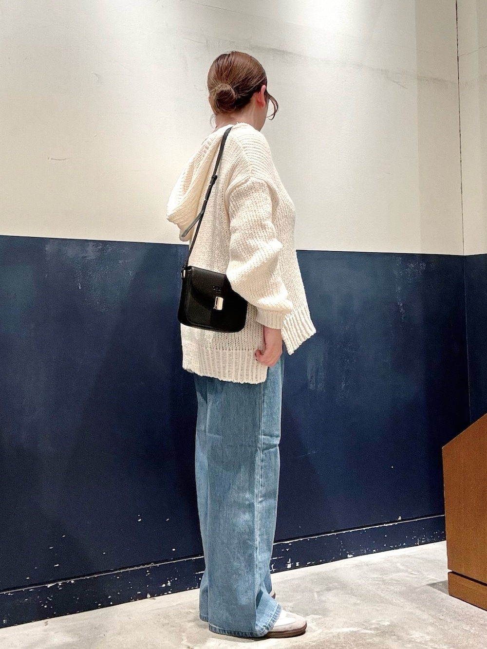 ホワイト系のTシャツ/カットソー、ブルー系のデニムパンツ、ブラック系のショルダーバッグを着用したレディースの秋コーディネートの2枚目の写真