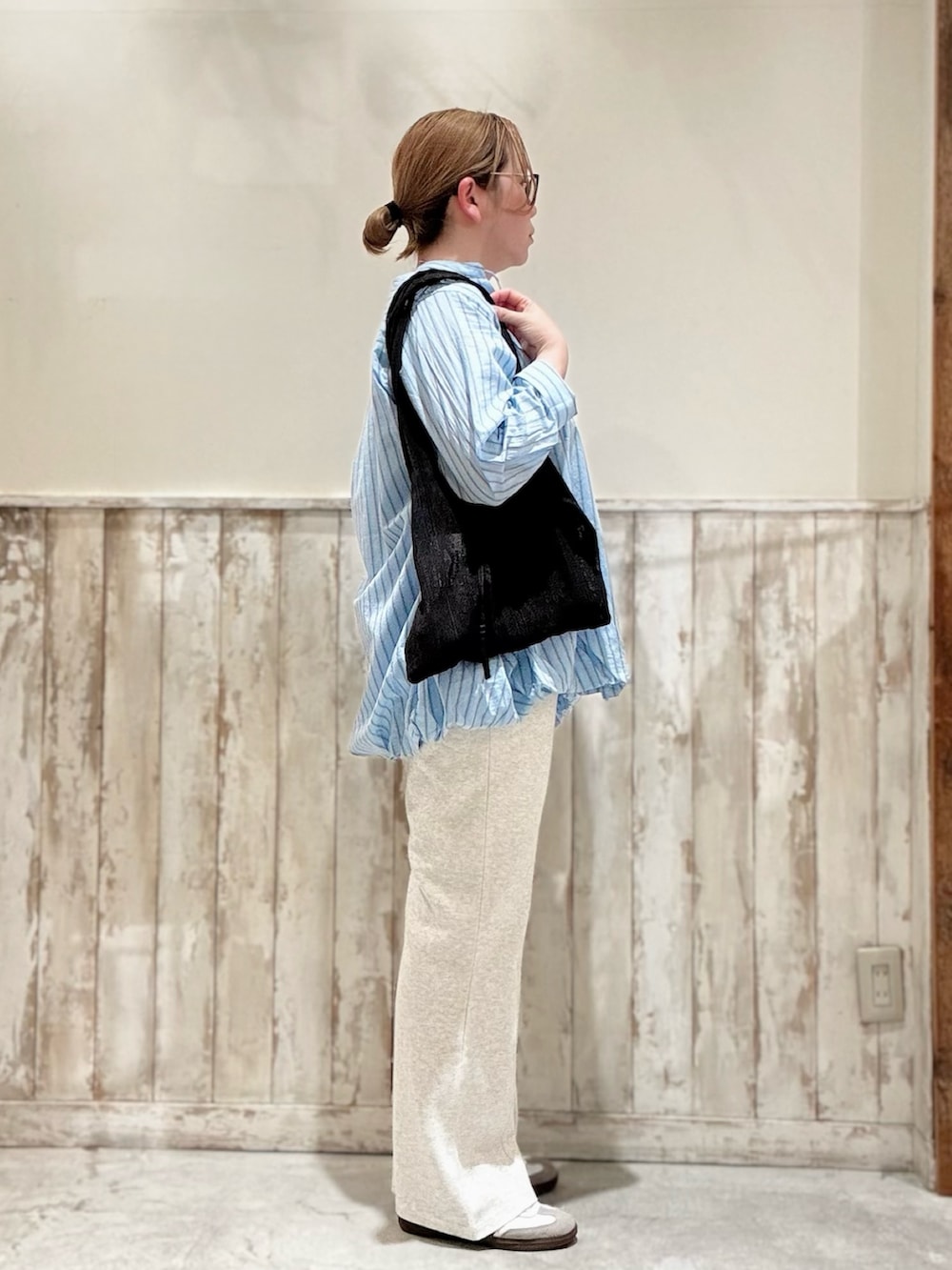 ブラック系のトートバッグ、ブルー系のシャツ/ブラウス、ブラック系のタンクトップを着用したレディースの春コーディネートの2枚目の写真