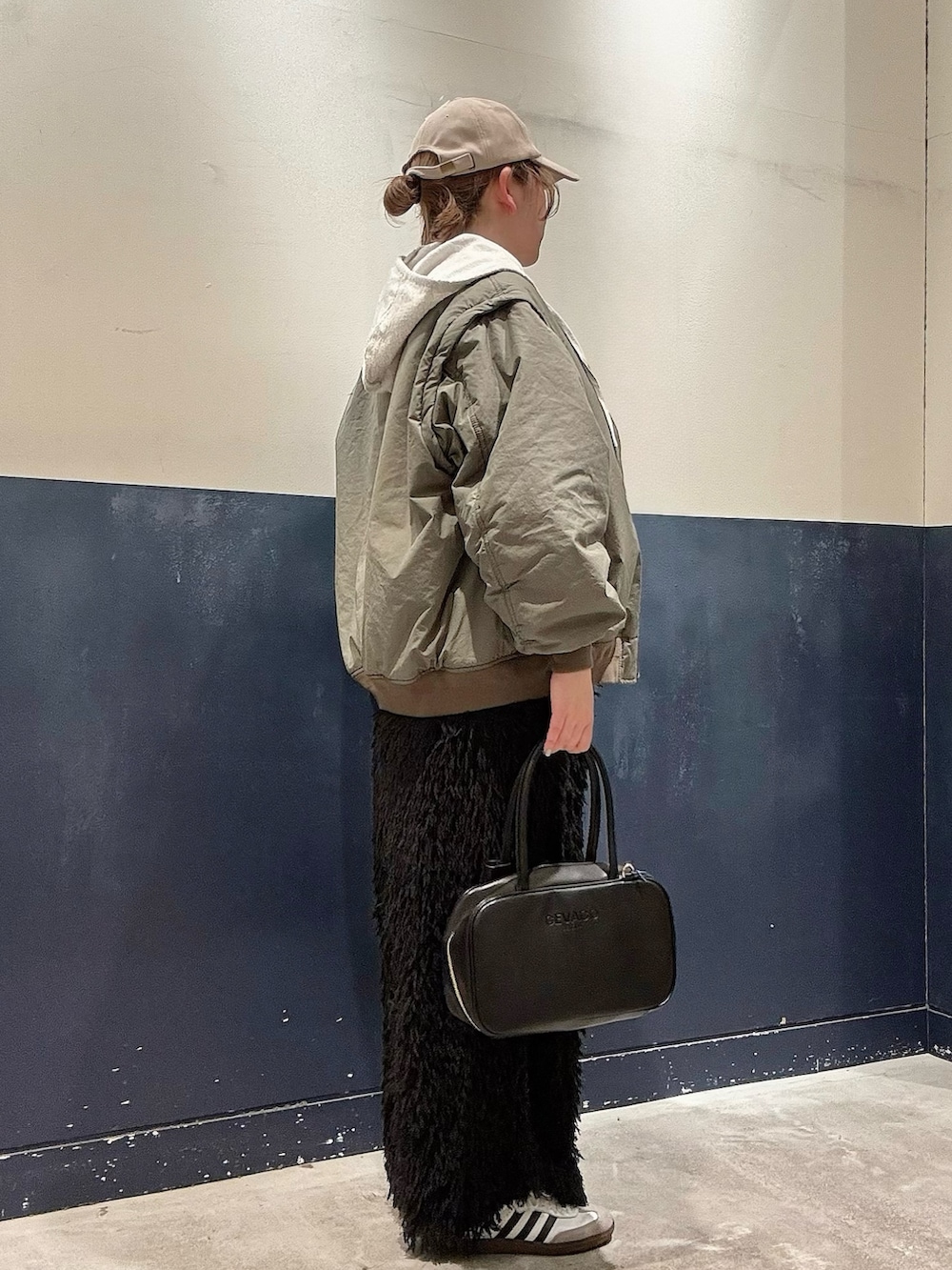 ブラック系のボストンバッグ、ブラック系のスカート、グリーン系のMA-1を着用したレディースの冬コーディネートの2枚目の写真