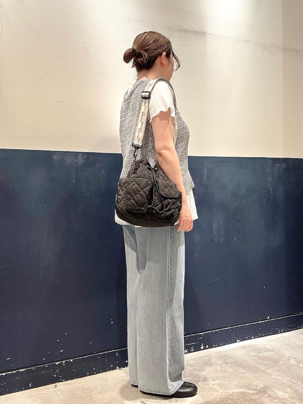 ブルー系のデニムパンツ、ブラック系のショルダーバッグ、ホワイト系のTシャツ/カットソーを着用したレディースの春コーディネートの2枚目の写真
