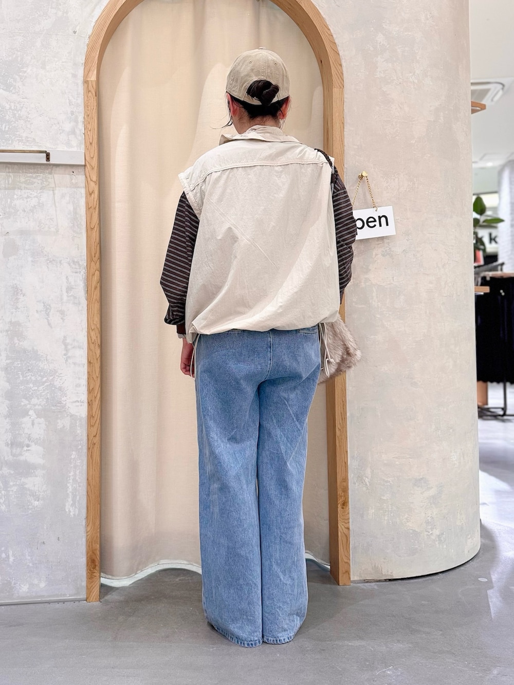 ブルー系のデニムパンツ、グレー系のナイロンジャケット、ブラウン系のTシャツ/カットソーを着用したレディースの秋コーディネートの3枚目の写真