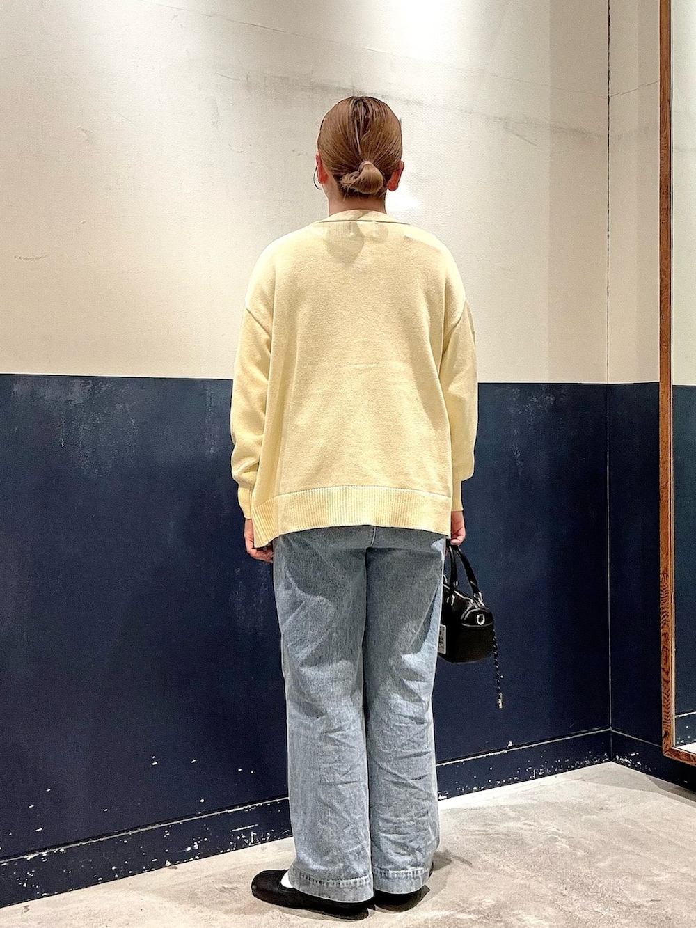 ブルー系のデニムパンツ、ブラック系のショルダーバッグ、グレー系のTシャツ/カットソーを着用したレディースの冬コーディネートの3枚目の写真