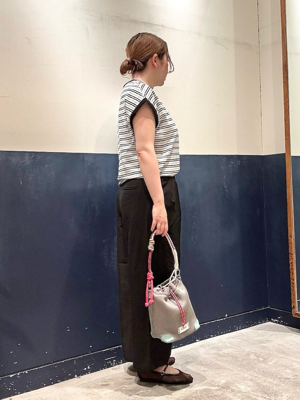 ブラック系のパンプス、グレー系のショルダーバッグ、ブラック系のスラックスを着用したレディースの春コーディネートの2枚目の写真