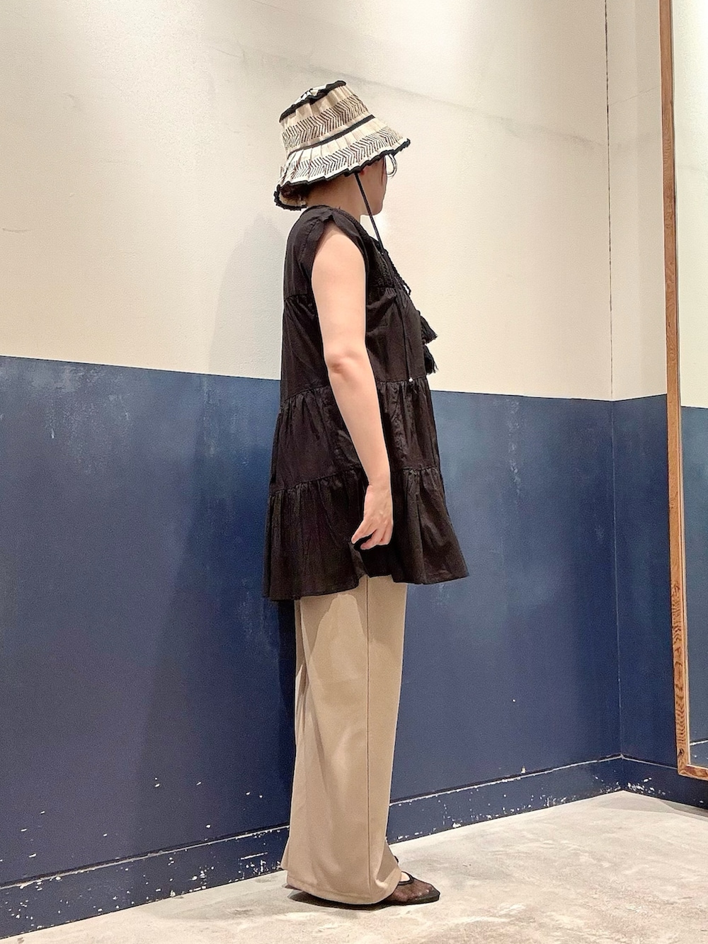 ブラック系のシャツ/ブラウス、ベージュ系のスラックス、ブラック系のパンプスを着用したレディースの夏コーディネートの2枚目の写真