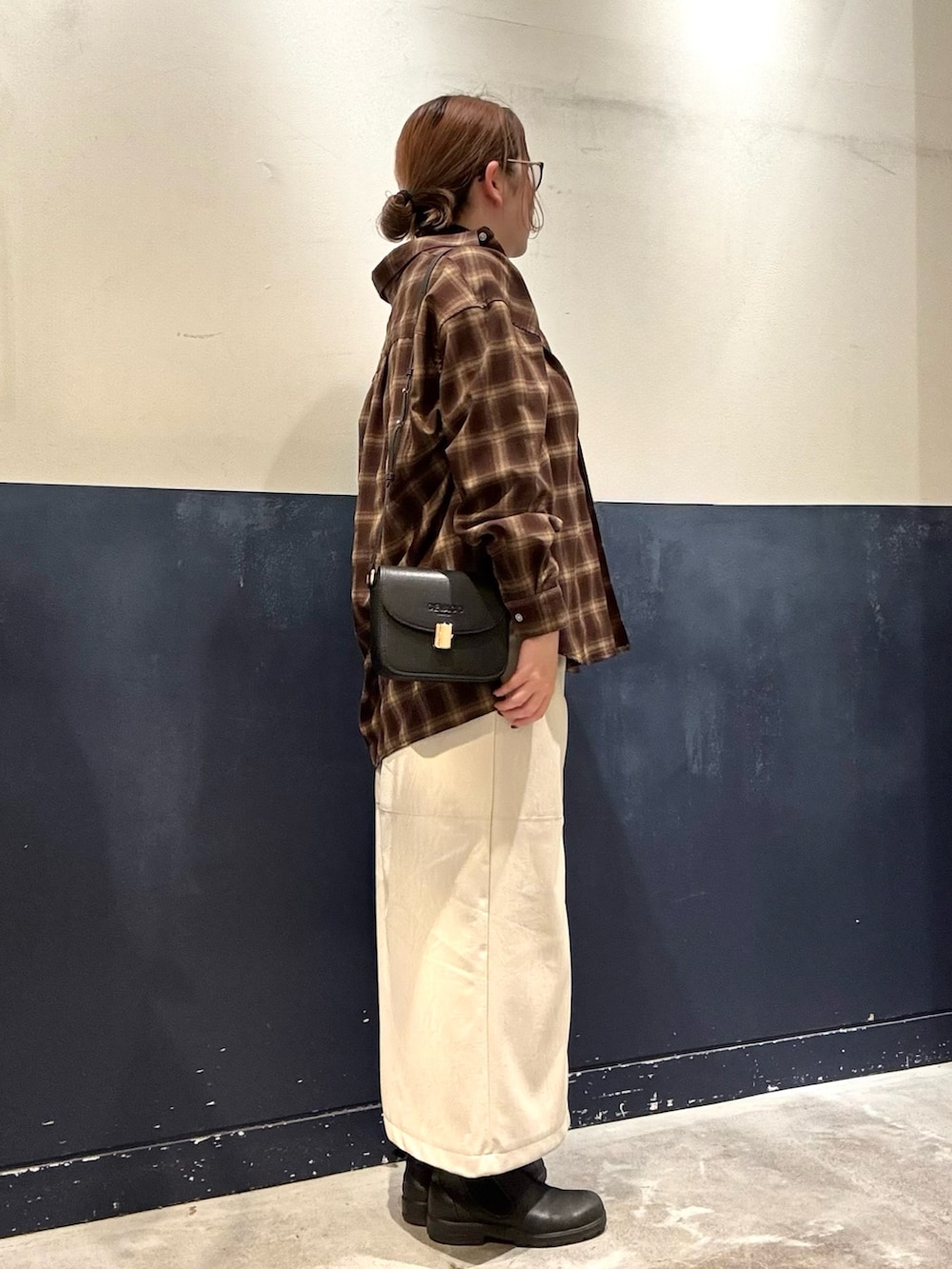 ホワイト系のスカート、ブラック系のショルダーバッグ、ブラウン系のシャツ/ブラウスを着用したレディースの秋コーディネートの2枚目の写真