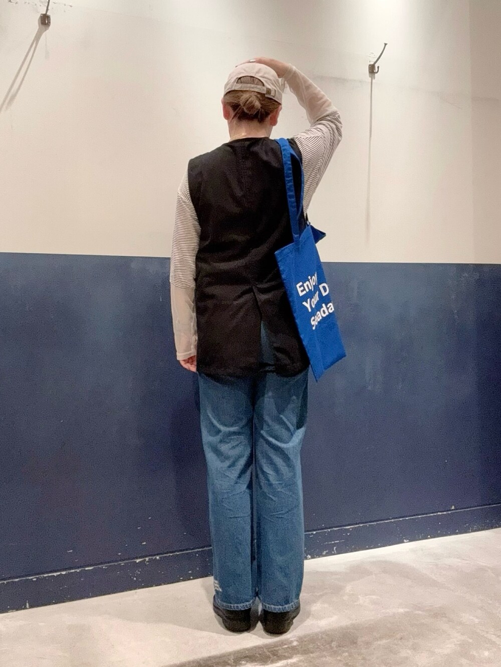 ブラック系のベスト、ホワイト系のTシャツ/カットソー、ブルー系のトートバッグを着用したレディースの夏コーディネートの3枚目の写真