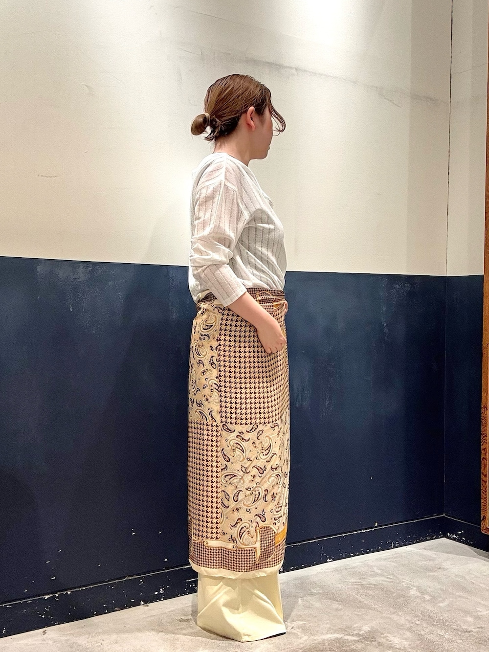 イエロー系のデニムパンツ、ブラック系のパンプス、ベージュ系のタンクトップを着用したレディースの春コーディネートの2枚目の写真