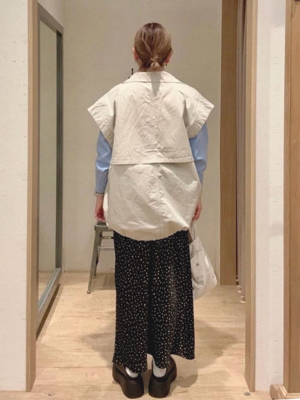 ブルー系のニット/セーター、ホワイト系のトートバッグ、ブラック系のスカートを着用したレディースの春コーディネートの2枚目の写真