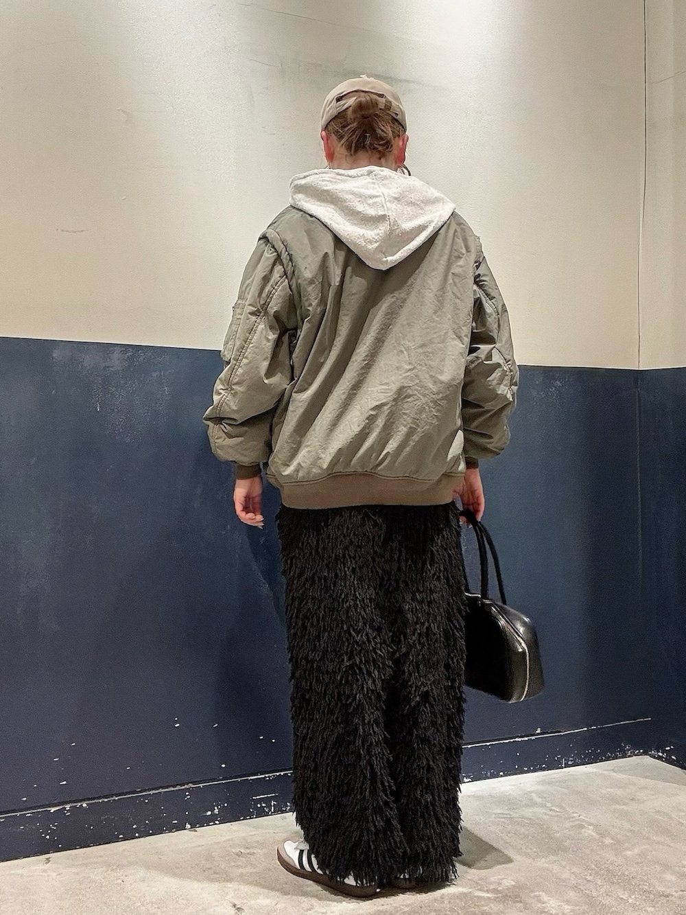 ブラック系のボストンバッグ、ブラック系のスカート、グリーン系のMA-1を着用したレディースの冬コーディネートの3枚目の写真