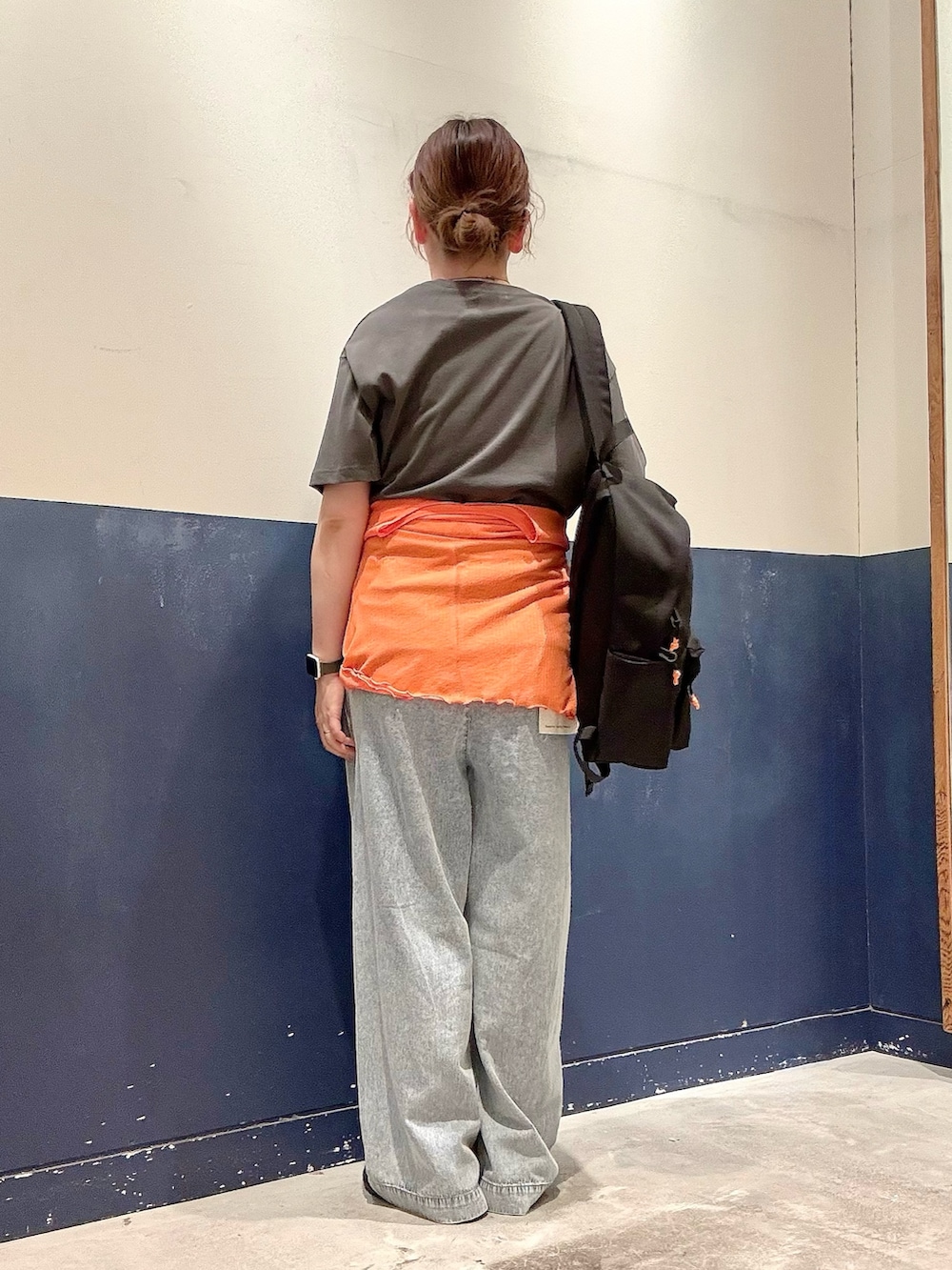 ブラック系のTシャツ/カットソー、オレンジ系のカーディガン/ボレロ、ブルー系のデニムパンツを着用したレディースの夏コーディネートの3枚目の写真