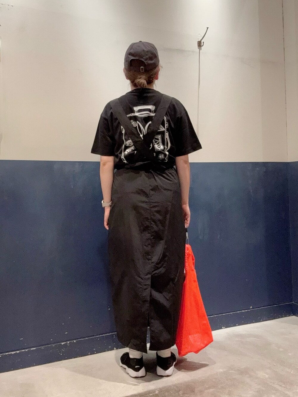 ブラック系のTシャツ/カットソー、オレンジ系のトートバッグ、ブラック系のスカートを着用したレディースの春コーディネートの3枚目の写真