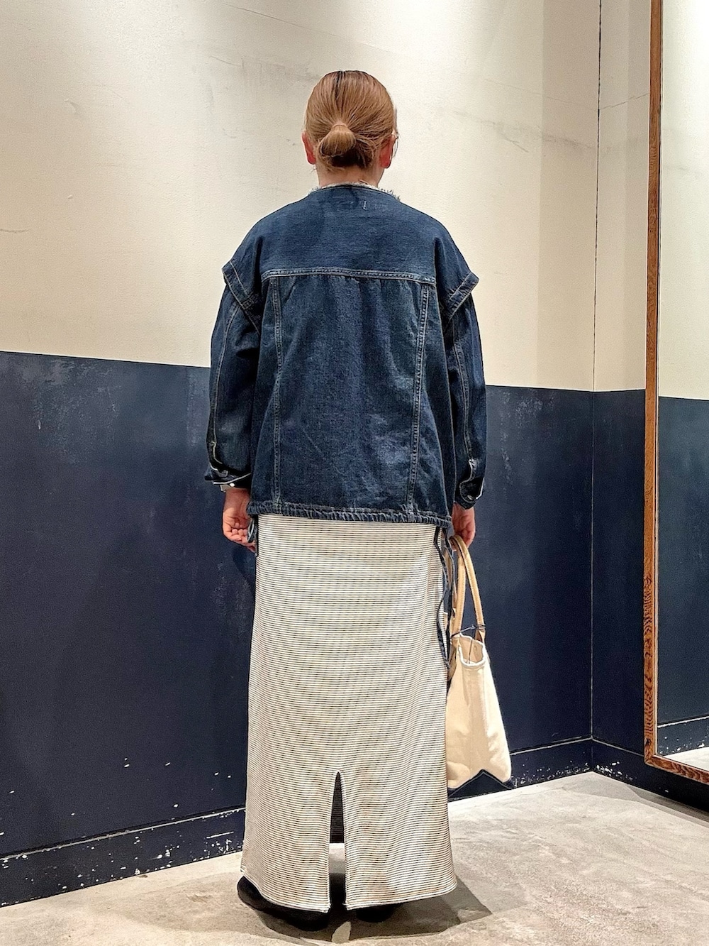 ブルー系のトートバッグ、ブルー系のデニムジャケット、ホワイト系のワンピースを着用したレディースの春コーディネートの3枚目の写真