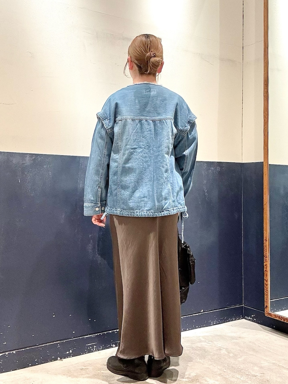 ホワイト系のTシャツ/カットソー、ブルー系のデニムジャケット、ブラック系のショルダーバッグを着用したレディースの冬コーディネートの3枚目の写真