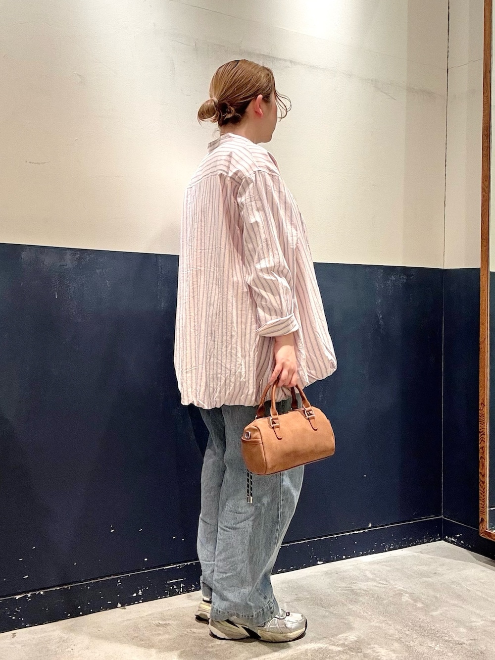 ベージュ系のショルダーバッグ、ブルー系のデニムパンツ、ピンク系のシャツ/ブラウスを着用したレディースの春コーディネートの2枚目の写真