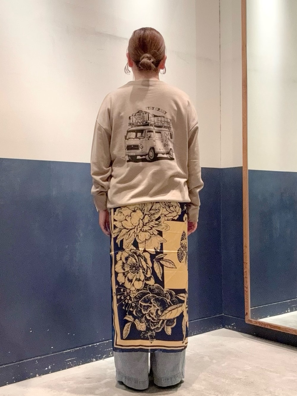 ブルー系のデニムパンツ、ベージュ系のスウェット、ブラック系のパンプスを着用したレディースの秋コーディネートの2枚目の写真