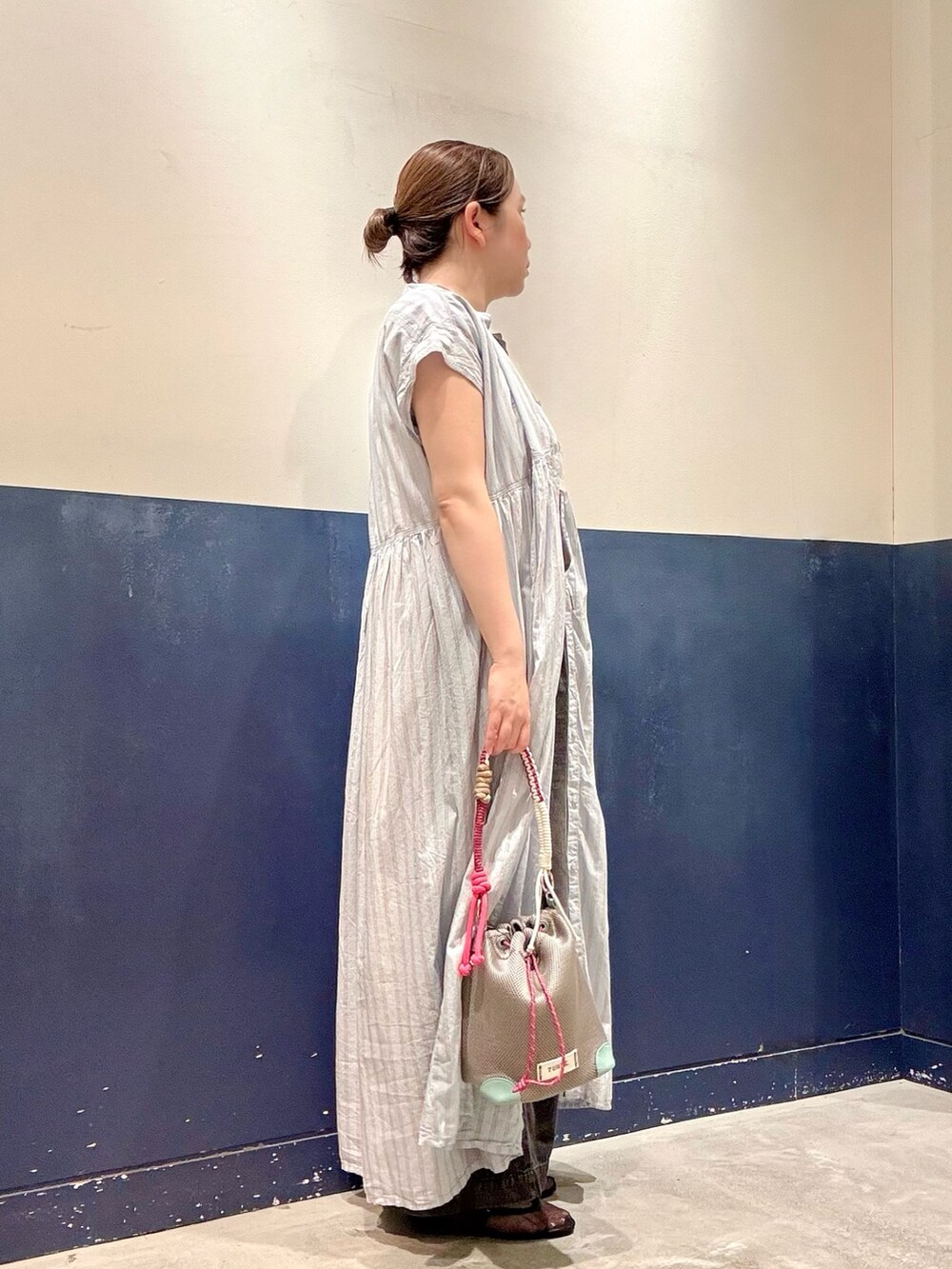 ブラック系のパンプス、グレー系のショルダーバッグ、ブラック系のデニムパンツを着用したレディースの夏コーディネートの2枚目の写真