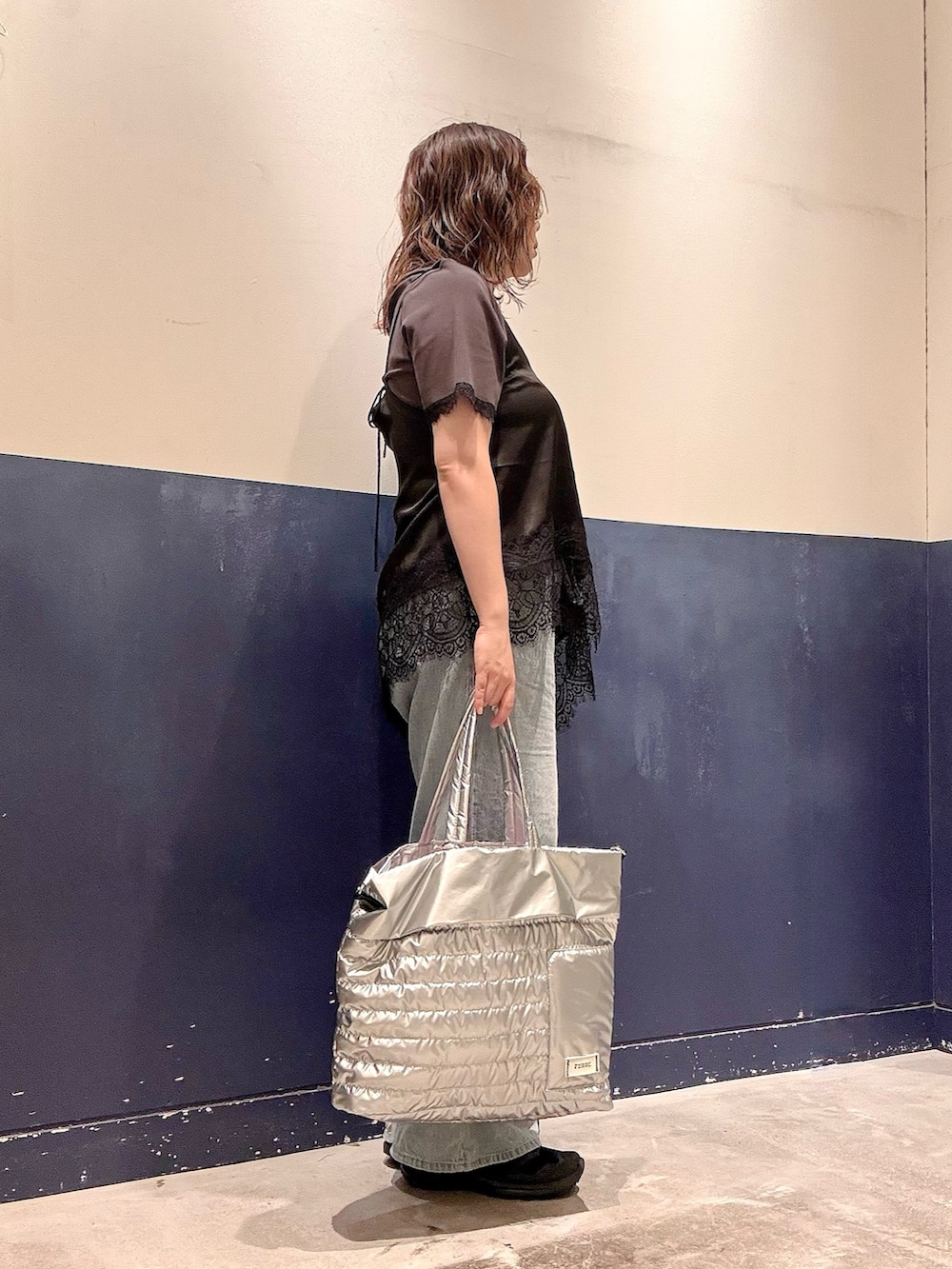 ブルー系のデニムパンツ、ブラック系のチュニック、グレー系のTシャツ/カットソーを着用したレディースの夏コーディネートの2枚目の写真