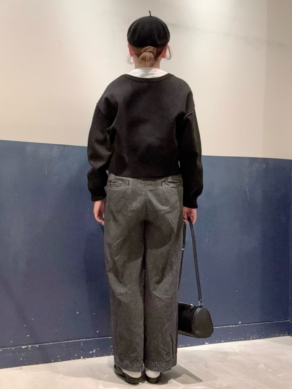 ブラック系のパンプス、ブラック系のデニムパンツ、ブラック系のショルダーバッグを着用したレディースの秋コーディネートの3枚目の写真