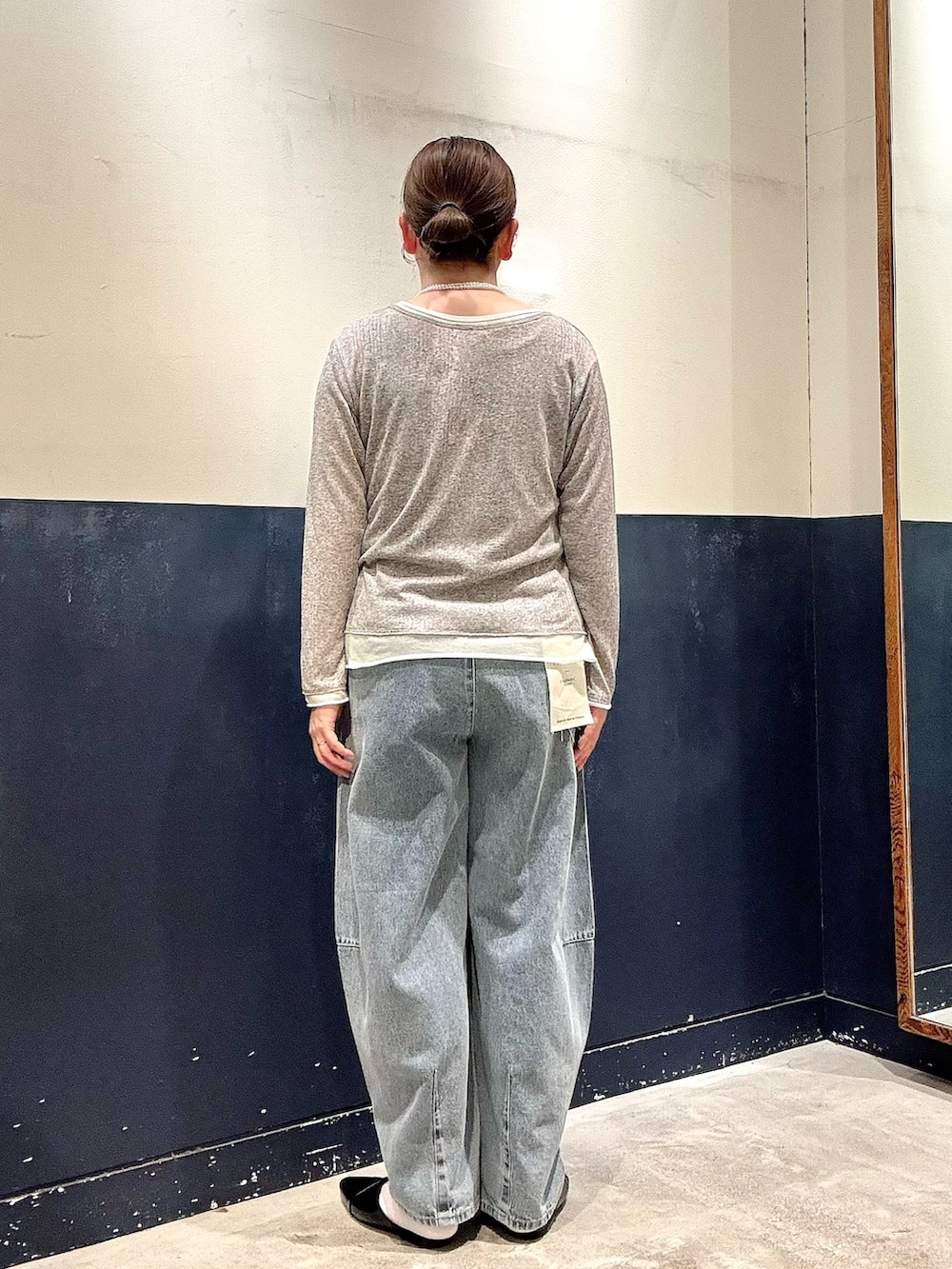 ブラック系のパンプス、ブルー系のデニムパンツ、グレー系のカーディガン/ボレロを着用したレディースの春コーディネートの3枚目の写真