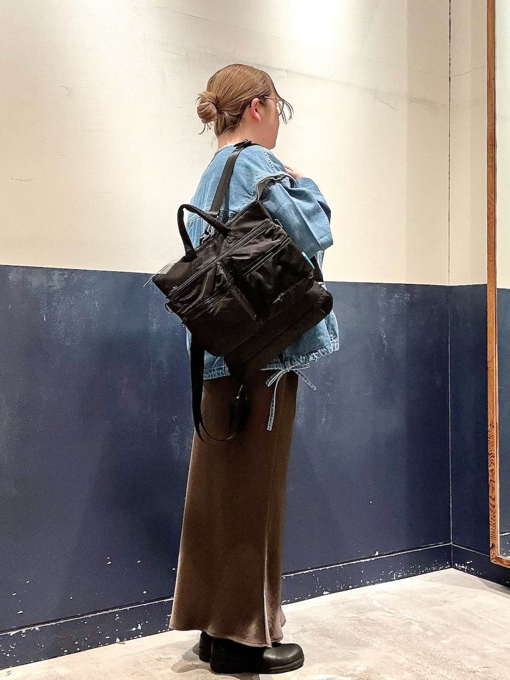 ホワイト系のTシャツ/カットソー、ブルー系のデニムジャケット、ブラック系のショルダーバッグを着用したレディースの冬コーディネートの2枚目の写真