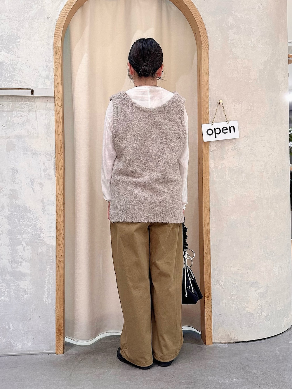 ブラック系のショルダーバッグ、ベージュ系のその他パンツ、ホワイト系のTシャツ/カットソーを着用したレディースの秋コーディネートの3枚目の写真