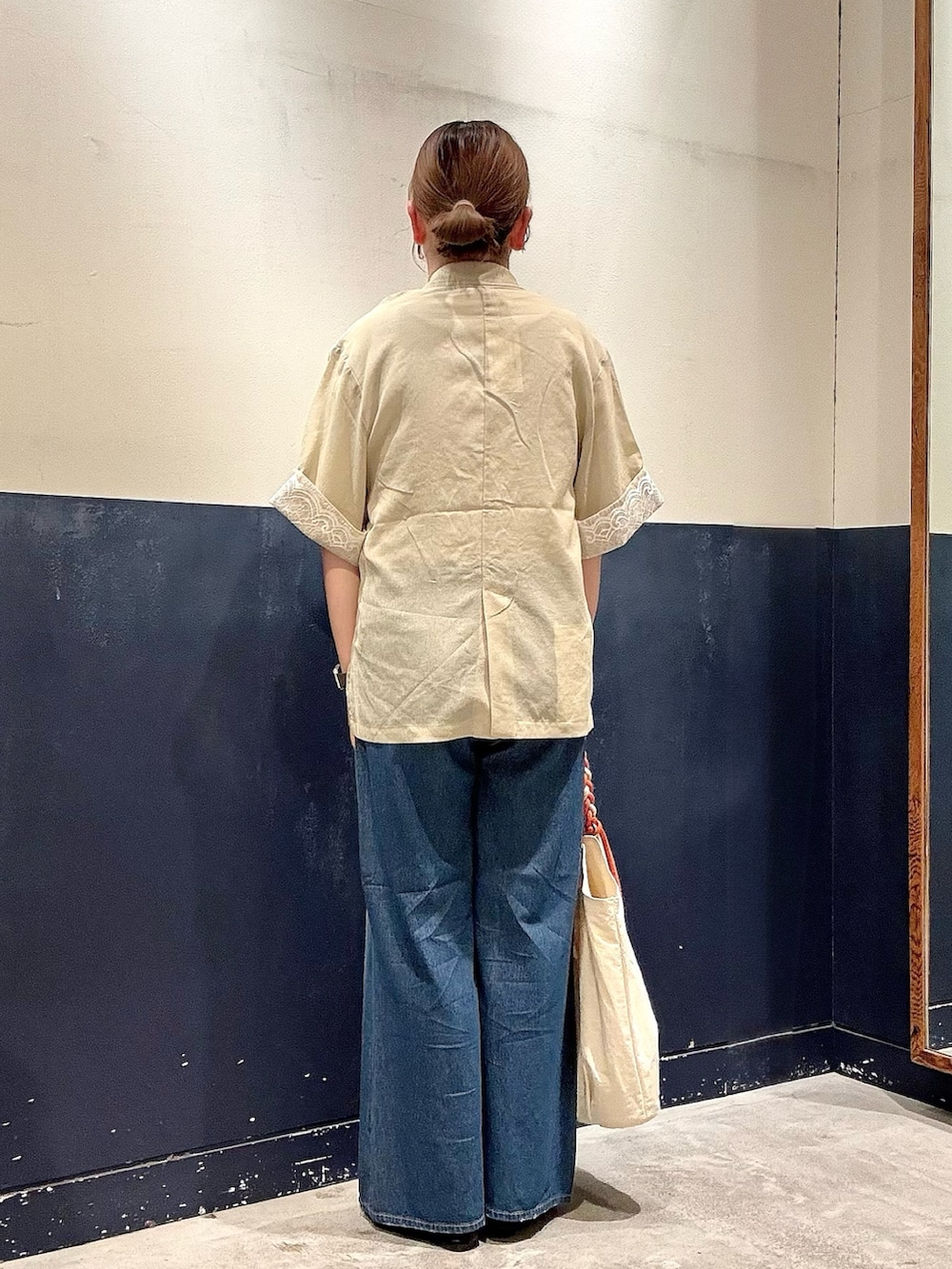 ブラック系のパンプス、ホワイト系のトートバッグ、ブルー系のデニムパンツを着用したレディースの春コーディネートの3枚目の写真