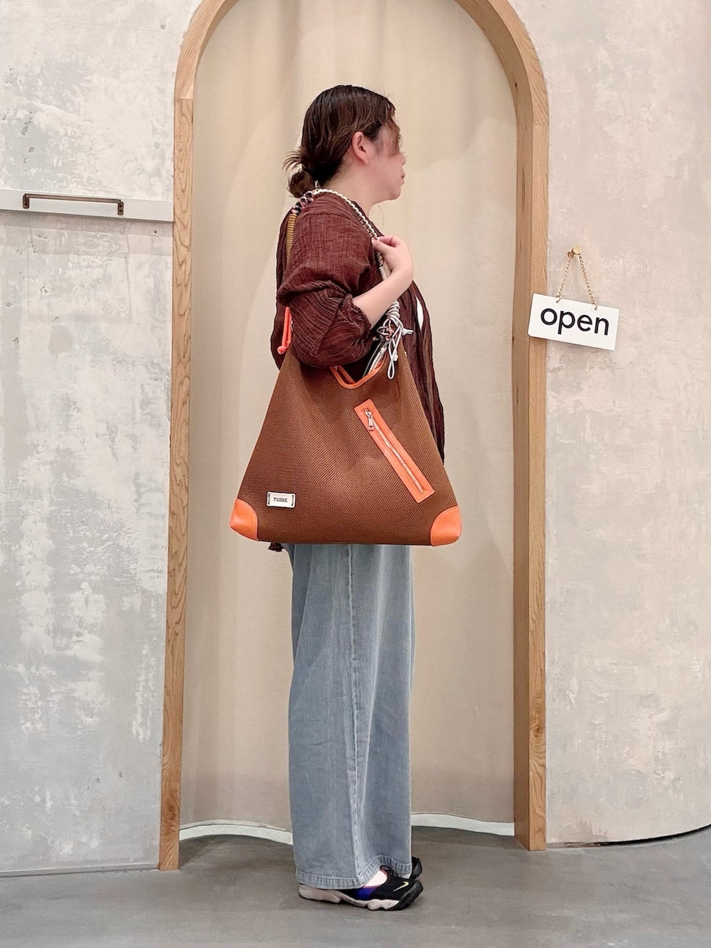 ブルー系のサロペット/オーバーオール、イエロー系のショルダーバッグ、ブラウン系のシャツ/ブラウスを着用したレディースの夏コーディネートの2枚目の写真