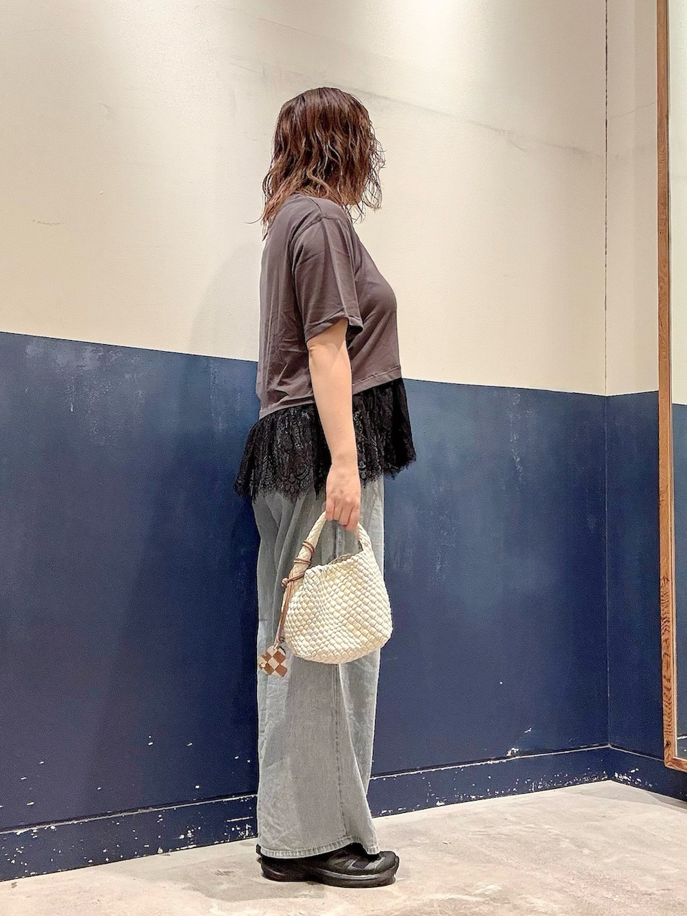 ホワイト系のショルダーバッグ、ブルー系のデニムパンツ、グレー系のTシャツ/カットソーを着用したレディースの夏コーディネートの2枚目の写真