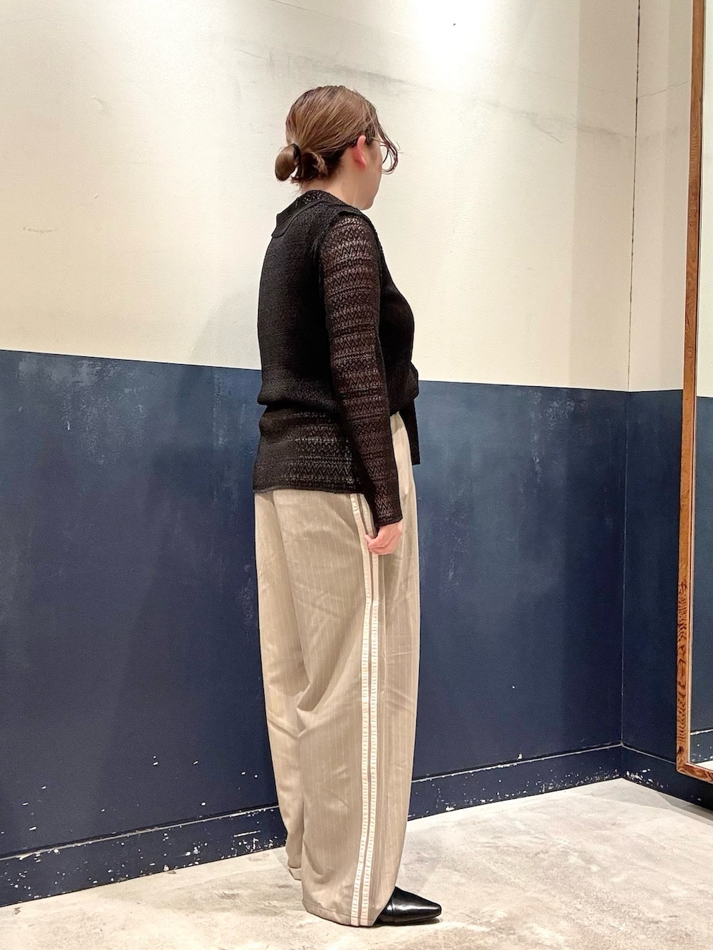 ブラック系のパンプス、ベージュ系のスラックス、ブラック系のタンクトップを着用したレディースの春コーディネートの2枚目の写真