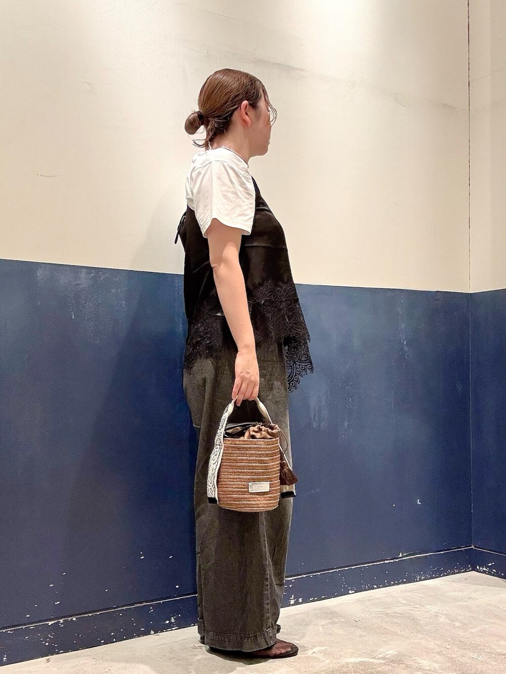 ブラウン系のトートバッグ、ブラック系のデニムパンツ、ブラック系のチュニックを着用したレディースの夏コーディネートの2枚目の写真