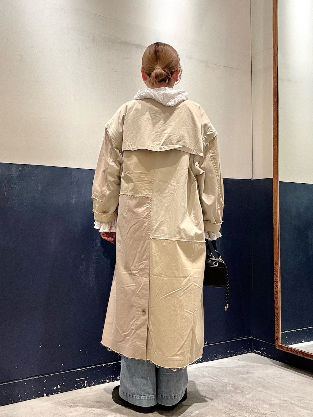 ホワイト系のシャツ/ブラウス、ベージュ系のトレンチコート、ブルー系のデニムパンツを着用したレディースの春コーディネートの3枚目の写真