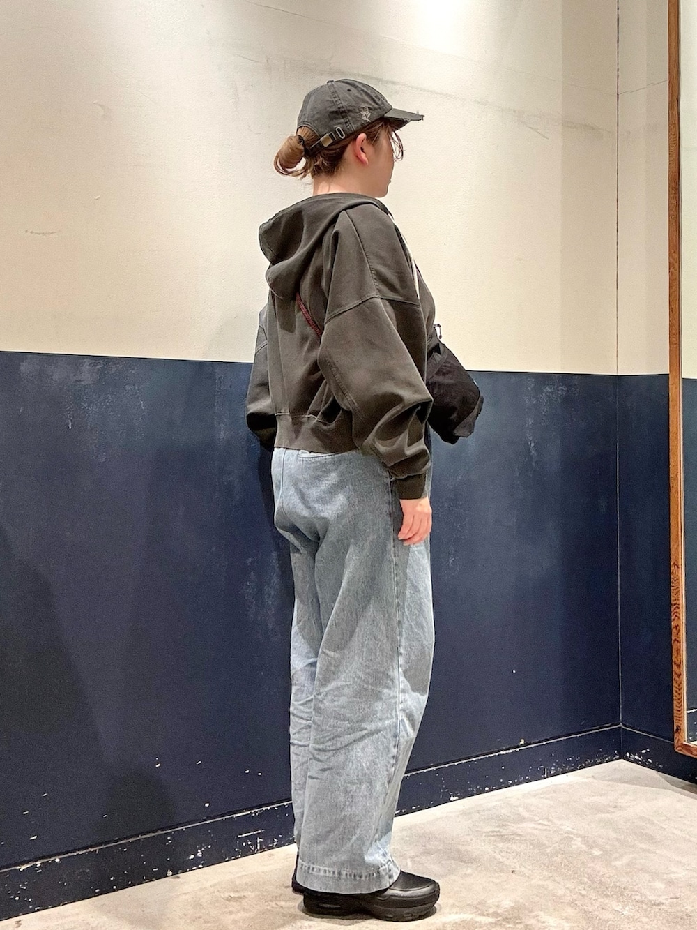 ブルー系のデニムパンツ、ブラック系のショルダーバッグ、グレー系のTシャツ/カットソーを着用したレディースの春コーディネートの2枚目の写真