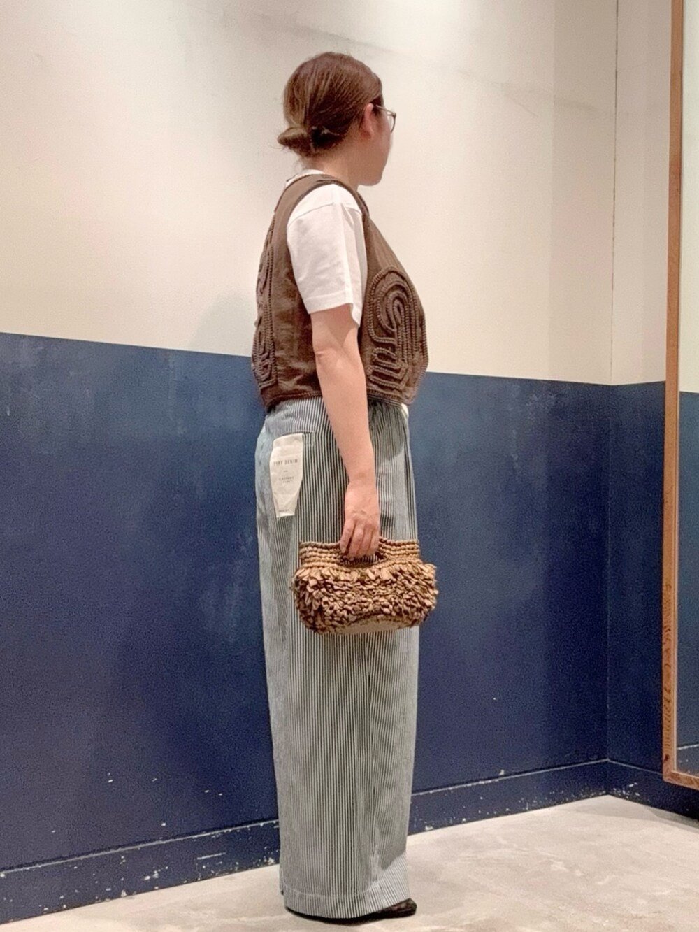 グレー系のTシャツ/カットソー、ブラウン系のベスト、ブラウン系のショルダーバッグを着用したレディースの夏コーディネートの2枚目の写真