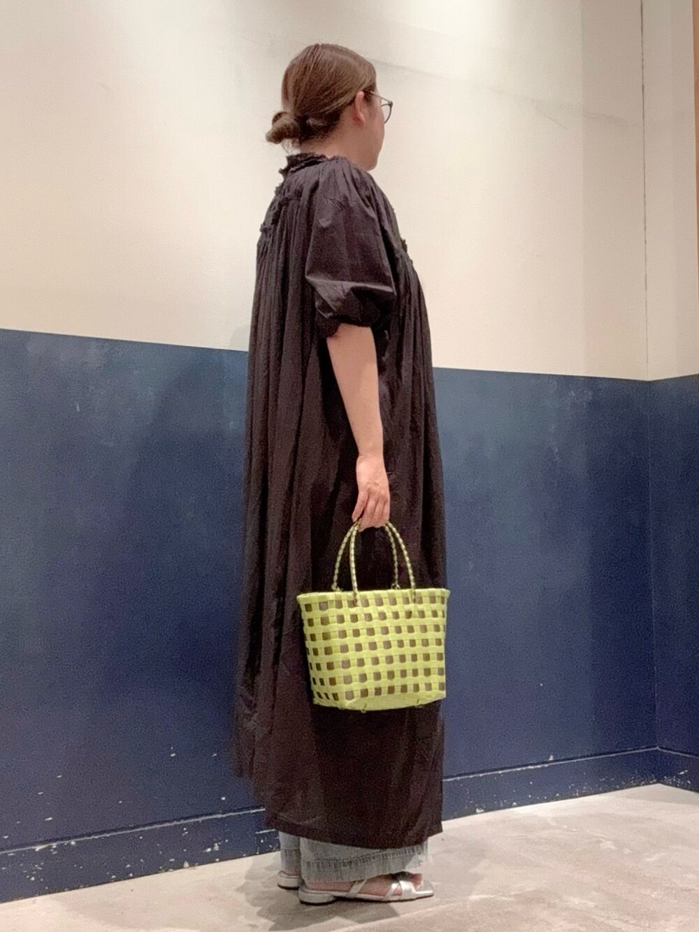 ブルー系のデニムパンツ、シルバー系のサンダル、グリーン系のトートバッグを着用したレディースの夏コーディネートの2枚目の写真