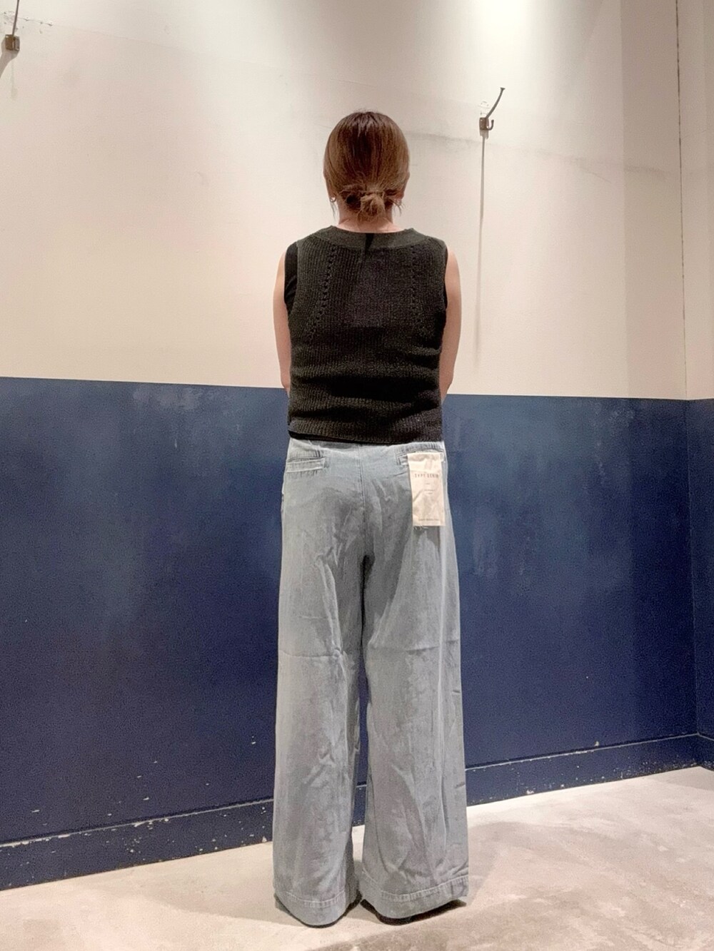 ブラック系のタンクトップ、グレー系のベスト、ブルー系のデニムパンツを着用したレディースの夏コーディネートの2枚目の写真