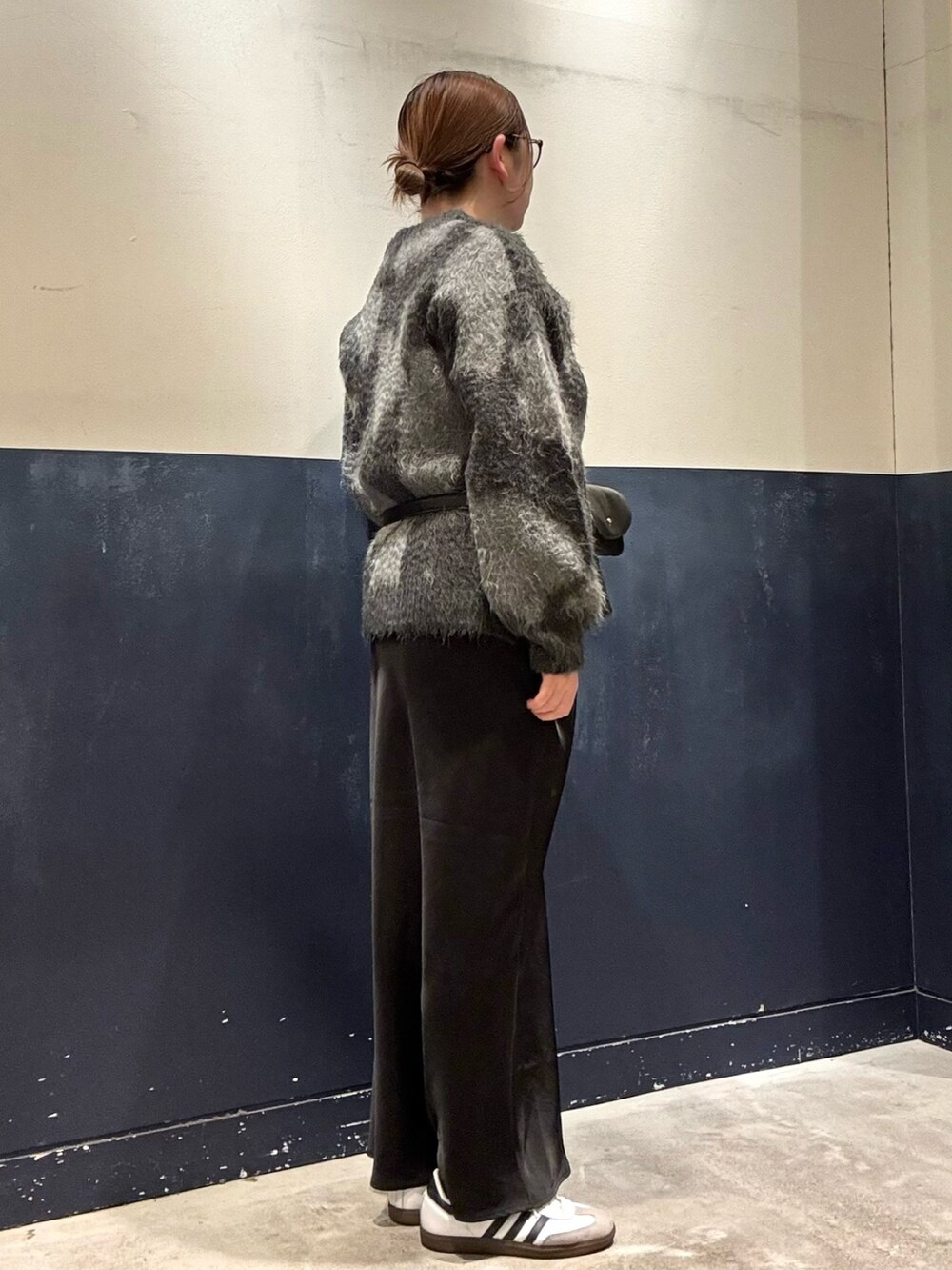 ブラック系のスカート、ブラック系のボディバッグ/ウエストポーチ、グレー系のニット/セーターを着用したレディースの冬コーディネートの2枚目の写真