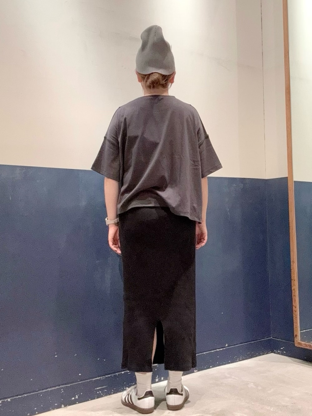 ブラック系のスカート、ブラック系のショルダーバッグ、グレー系のTシャツ/カットソーを着用したレディースの秋コーディネートの3枚目の写真