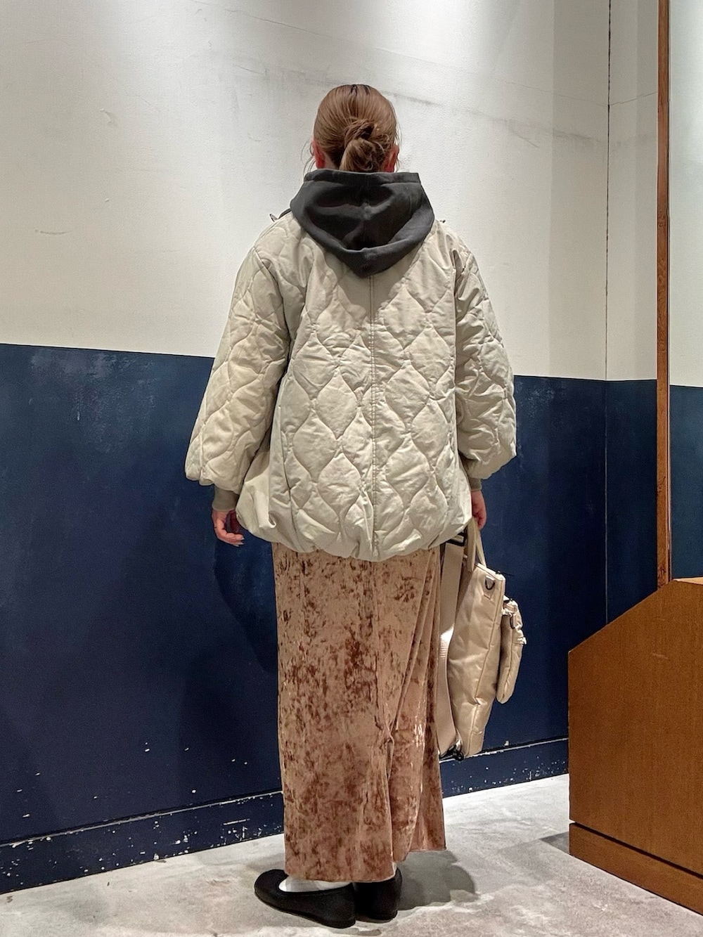 グリーン系のブルゾン、グレー系のTシャツ/カットソー、ベージュ系のショルダーバッグを着用したレディースの冬コーディネートの3枚目の写真