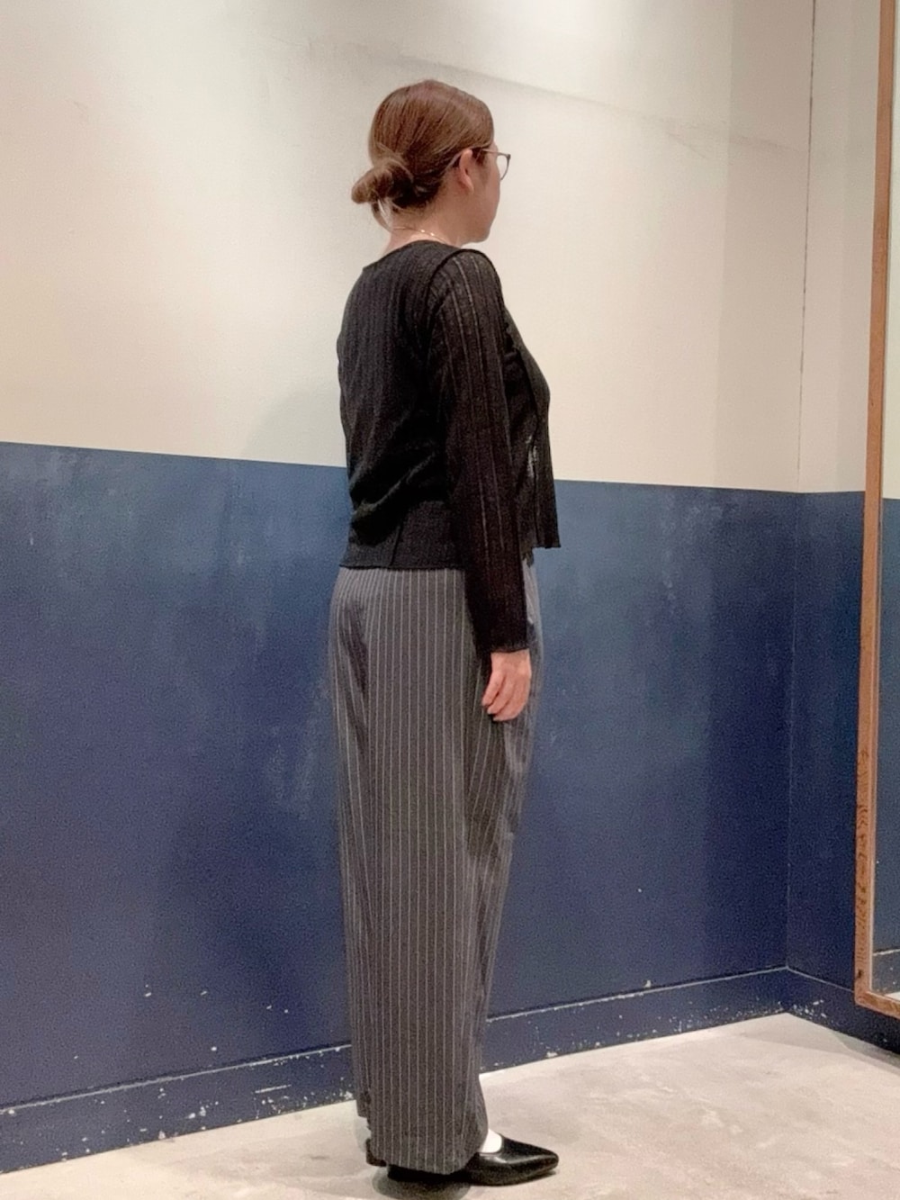 ブラック系のパンプス、グレー系のスラックス、ブラック系のタンクトップを着用したレディースの秋コーディネートの2枚目の写真