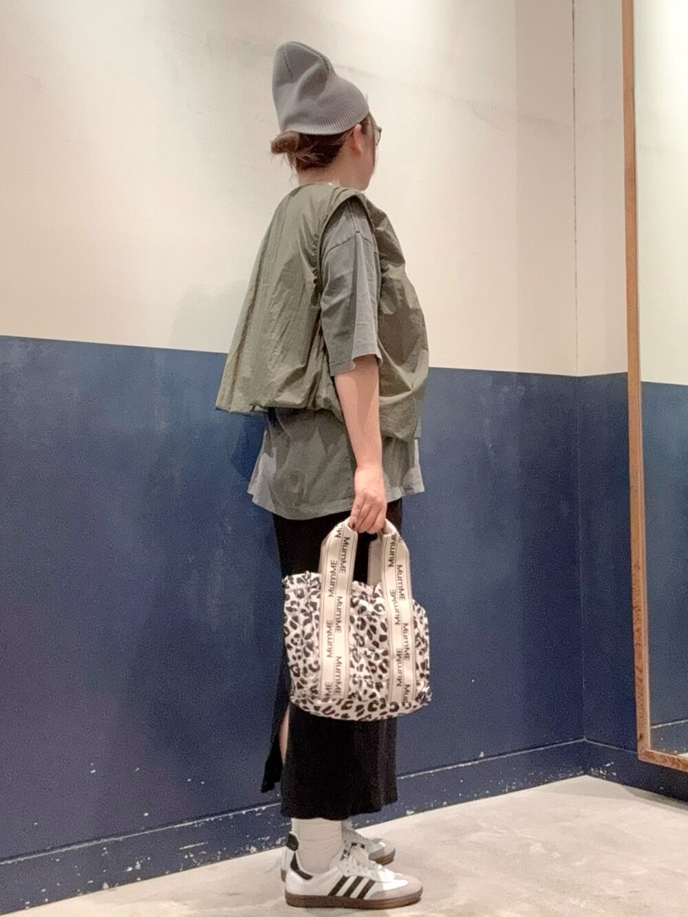 ブラック系のTシャツ/カットソー、グリーン系のベスト、ブラック系のスカートを着用したレディースの秋コーディネートの2枚目の写真