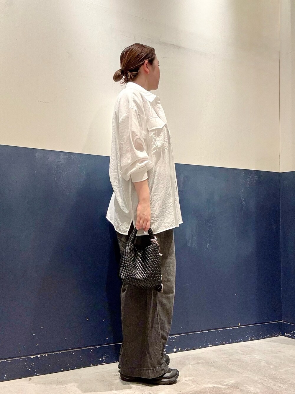 ブラック系のショルダーバッグ、ブラック系のデニムパンツ、ホワイト系のTシャツ/カットソーを着用したレディースの夏コーディネートの2枚目の写真