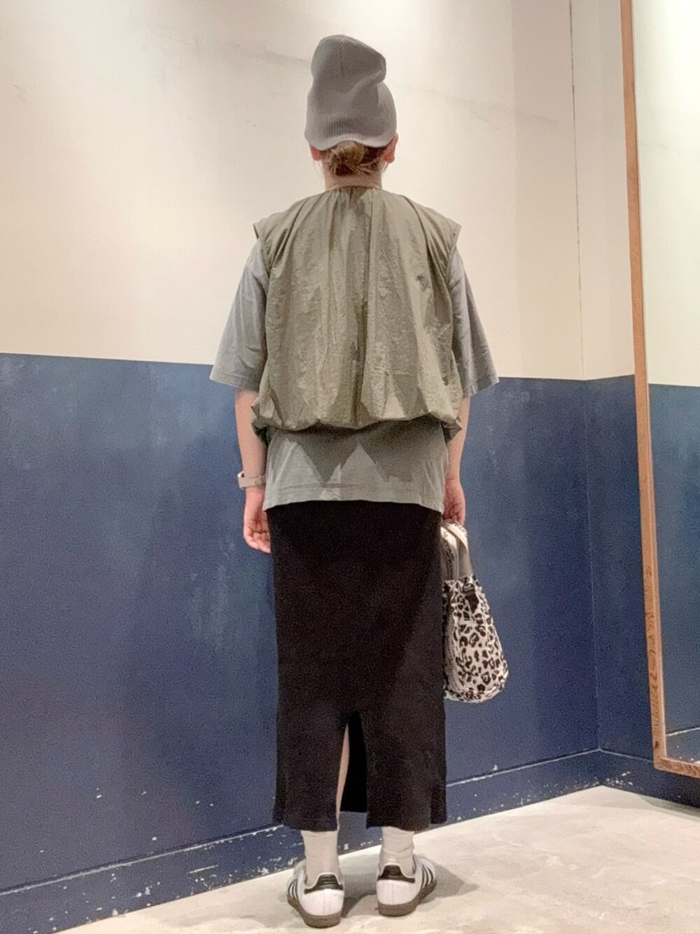 ブラック系のTシャツ/カットソー、グリーン系のベスト、ブラック系のスカートを着用したレディースの秋コーディネートの3枚目の写真