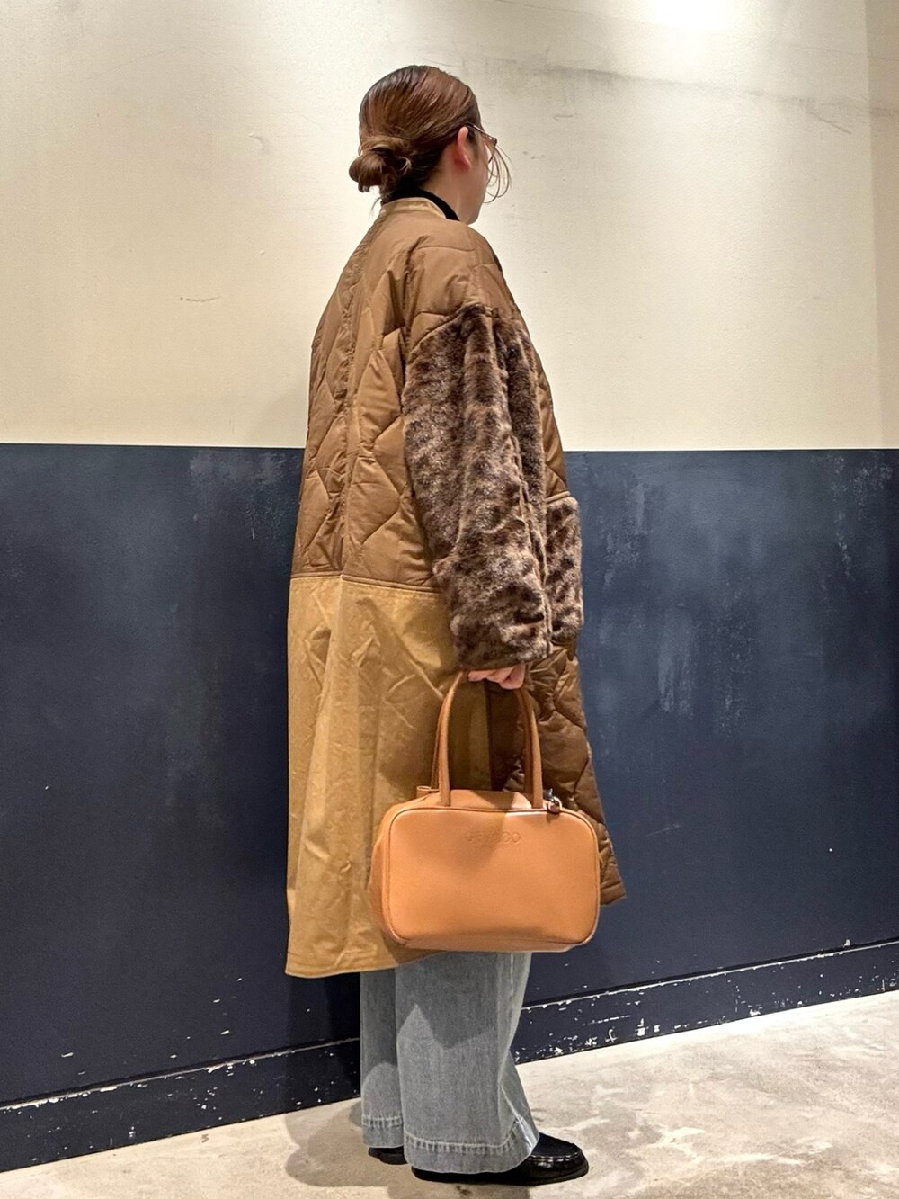 ブラック系のローファー、ブラック系のニット/セーター、ブラウン系のノーカラーコートを着用したレディースの冬コーディネートの2枚目の写真